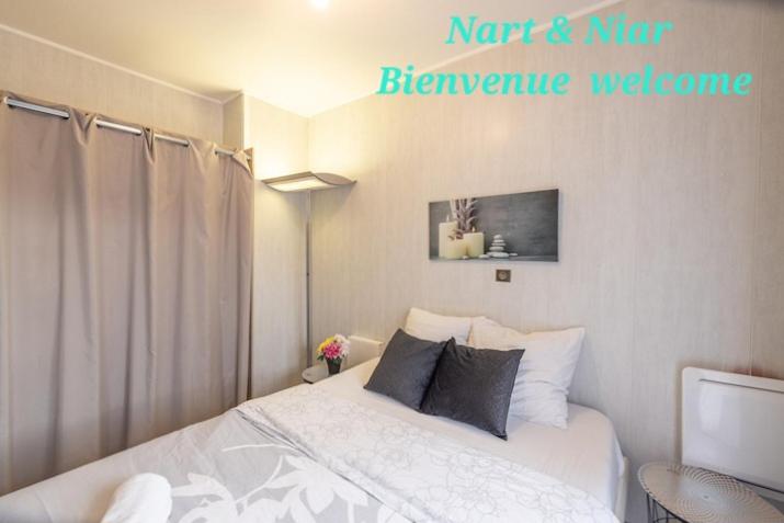 1 dormitorio con 1 cama y un cartel en la pared en Nart&Niar en Annemasse