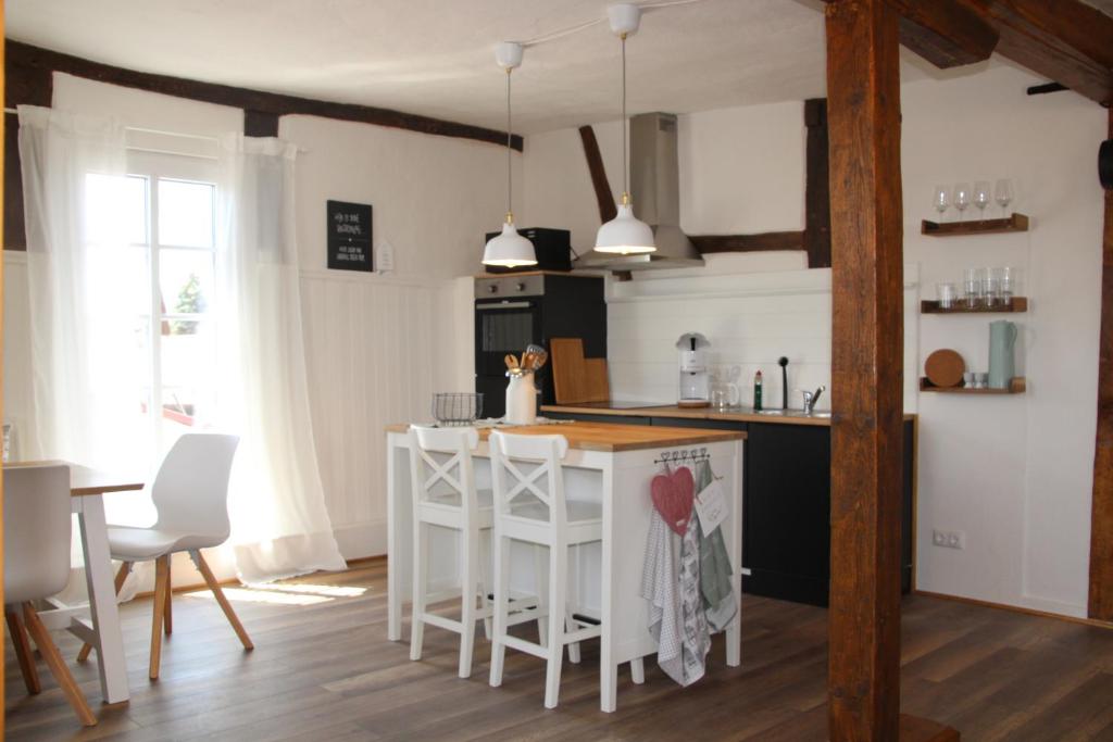 a kitchen with a white island in a room at Ferienwohnung - Zur alten Wirtsstube 