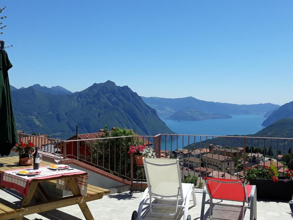 ein Balkon mit zwei Stühlen und einem Tisch und einer Aussicht in der Unterkunft Home Iseo Lake in Bossico