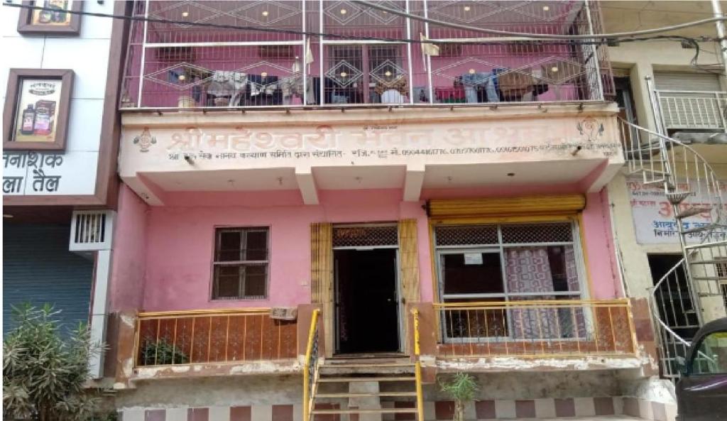 ein rosafarbenes Haus mit Balkon darüber in der Unterkunft Maheshwari Bhavan By WB Inn in Sītāpur Mūāfi
