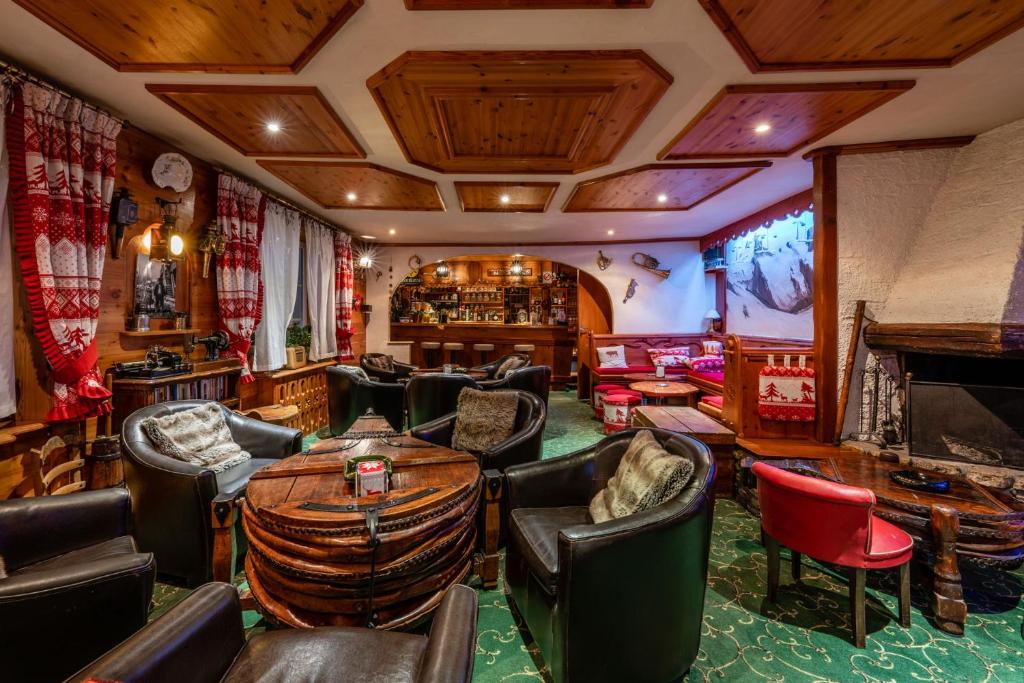 a room with a bar with chairs and a table at Logis Hôtel et Spa Le Christiania in La Salle-les-Alpes