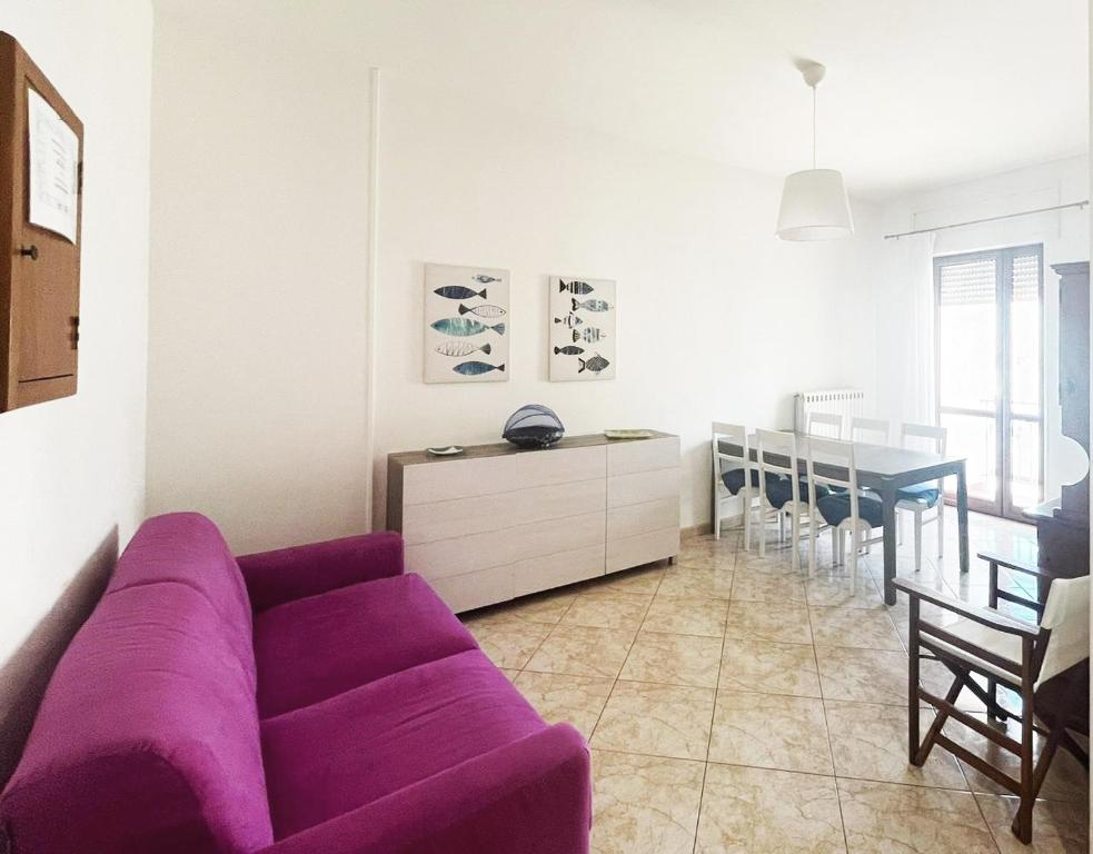 uma sala de estar com um sofá roxo e uma sala de jantar em Casa Vacanze da Silvy & Gio em Otranto