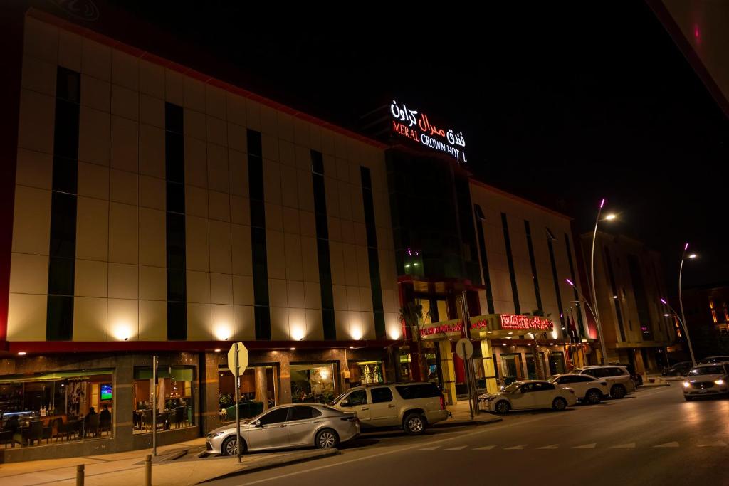 een stadsstraat met auto's die voor een gebouw geparkeerd staan bij Meral Crown Hotel in Riyad