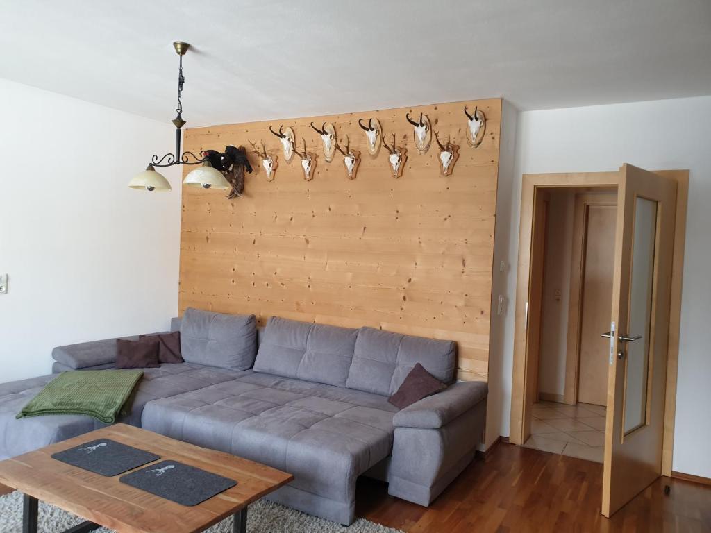 a living room with a couch and a wall with antlers at Ferienwohnung Jäger in Strassen