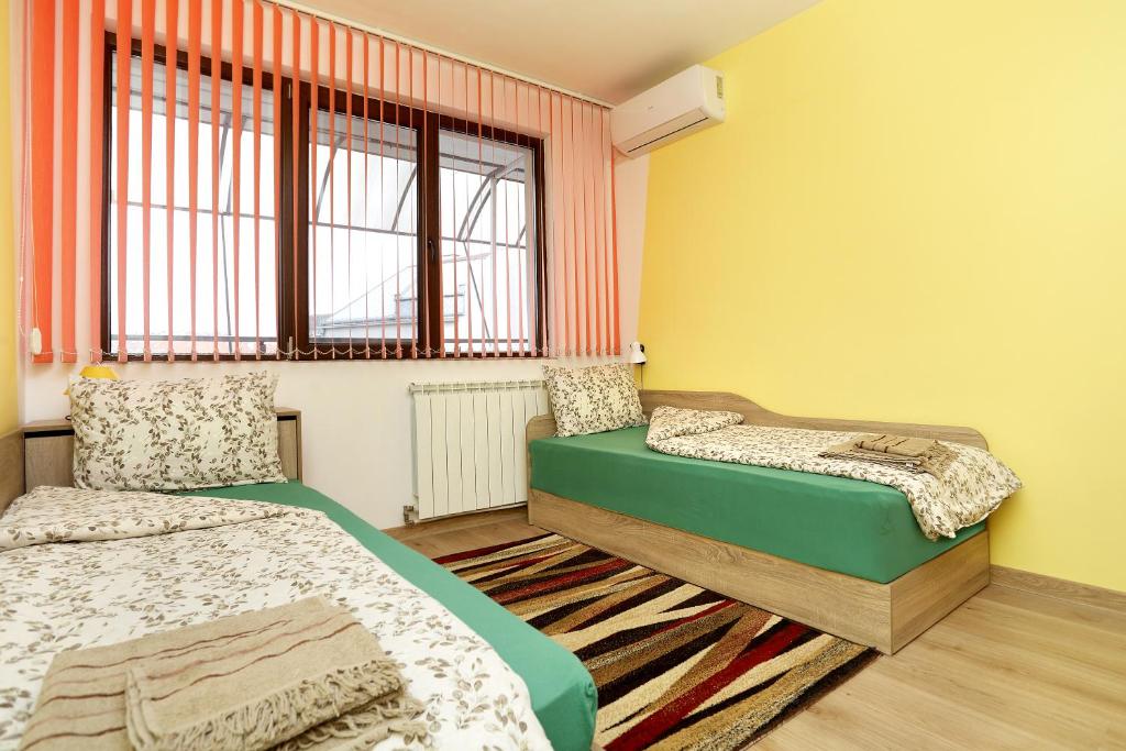 a bedroom with two beds and a window at Детелина in Ruse