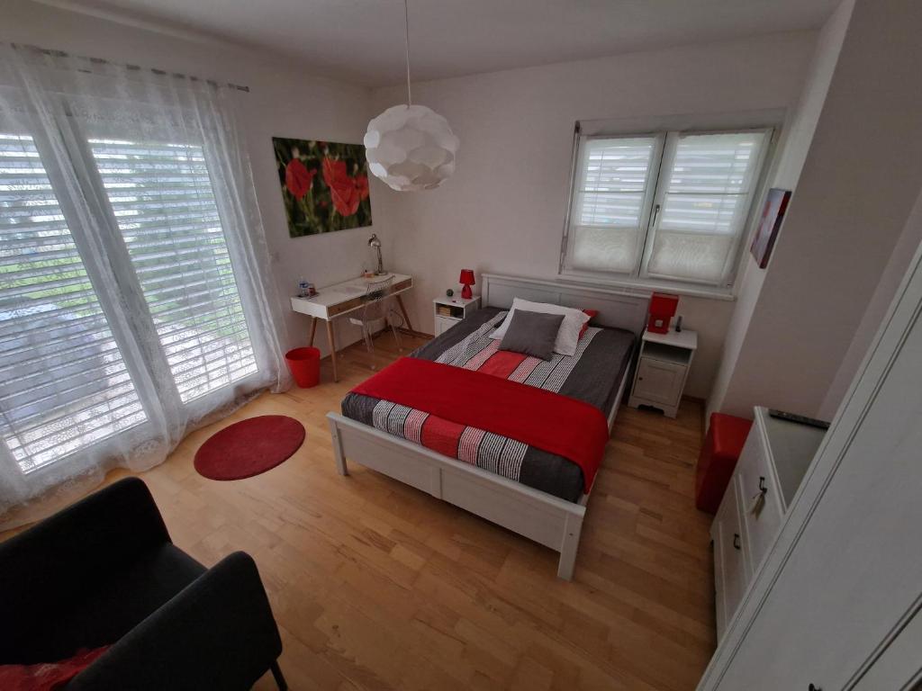 a bedroom with a bed with a red blanket at BnB "Les Coquelicots" in Mies