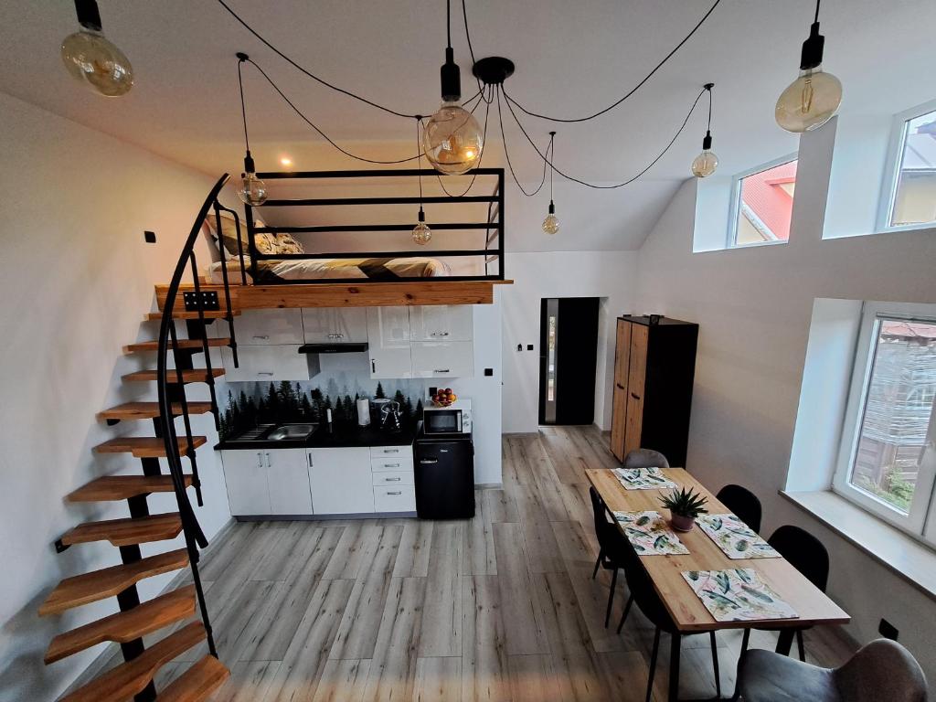 une chambre avec un escalier, une table et une cuisine dans l'établissement Apartament z antresolą, à Mikoszewo