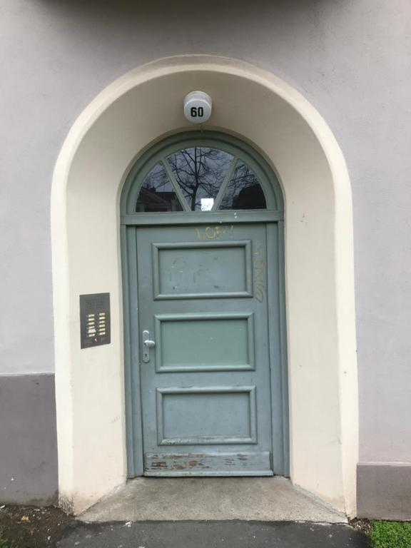 une porte verte dans un bâtiment blanc avec une arche dans l'établissement KASSEL @ YSENBURGSTRASSE, à Cassel