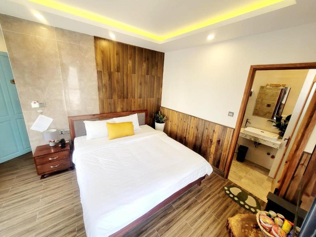 a bedroom with a large white bed and a mirror at Thung Lũng Kim Khuê Villas in Da Lat