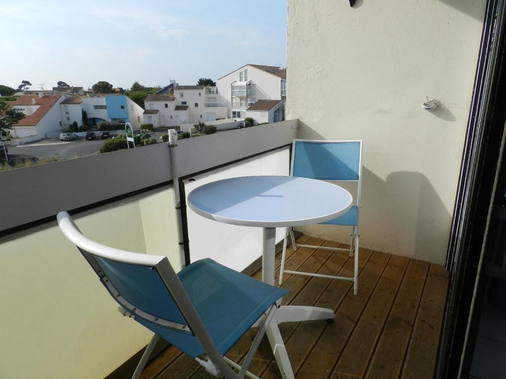 une table et deux chaises assises sur un balcon dans l'établissement Charmant studio avec piscine à La Rochelle, proche port des Minimes, commerces et bus - FR-1-551-30, à La Rochelle