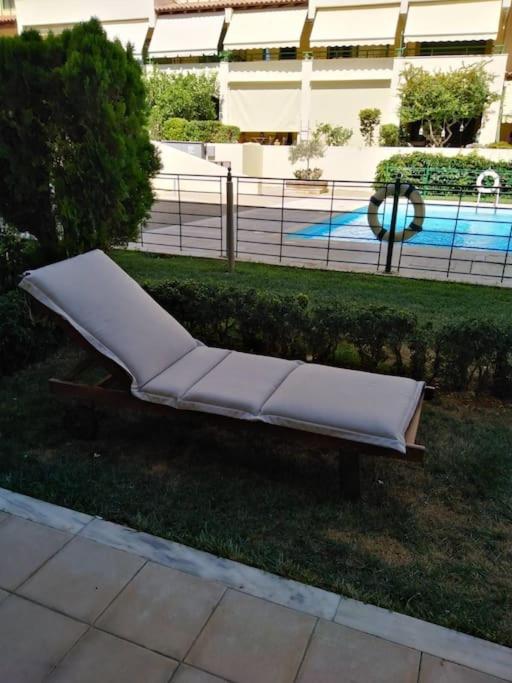 ein weißes Sofa im Gras in der Nähe eines Gebäudes in der Unterkunft Luxury Apartment with Pool View in Xylokastro