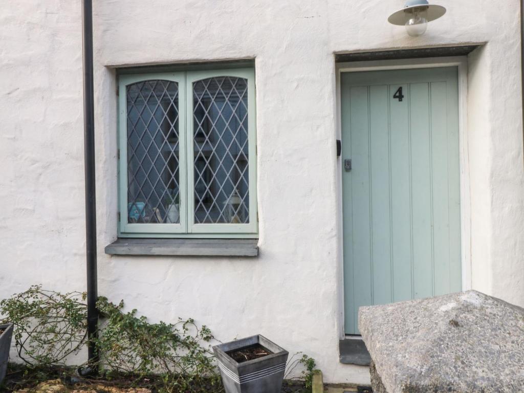 una casa con una puerta azul y una ventana en Ty Crydd, en Kidwelly