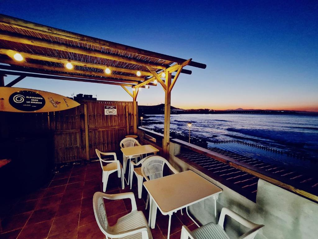 un patio con mesas y sillas y el océano en GRAN CANARIA Oasis La Guancha, en Gáldar