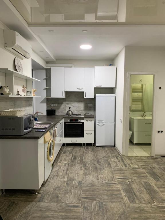 eine Küche mit weißen Geräten und Holzböden in der Unterkunft Квартира с отдельным входом с улицы in Chişinău
