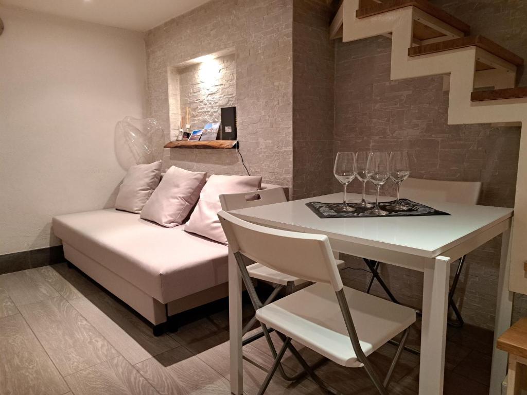 ein Wohnzimmer mit einem Sofa und einem Tisch mit Weingläsern in der Unterkunft TOLEDO 27, a due passi da Piazza del Plebiscito in Neapel