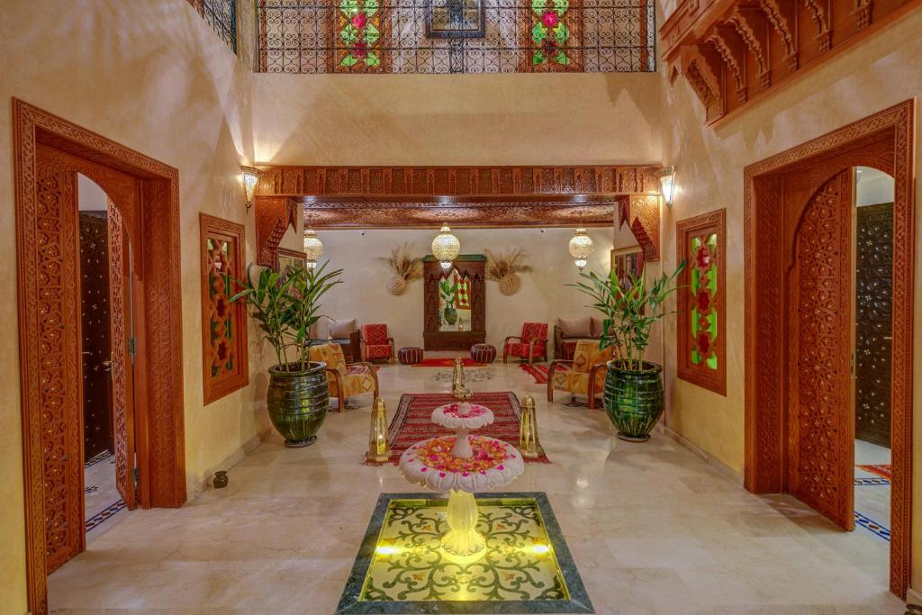 a living room with a table and some chairs at Riad Diamond Of Marrakech in Marrakech