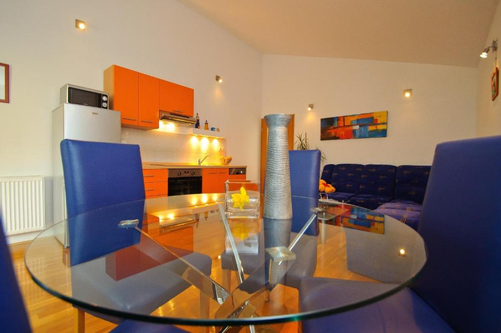 a glass table in a living room with blue chairs at Apartment Lea in Trogir