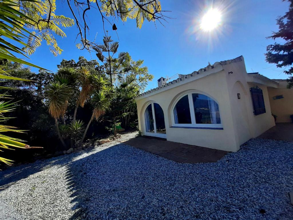 una casa bianca con il sole nel cielo di Vistas al lago with private pool a Viñuela