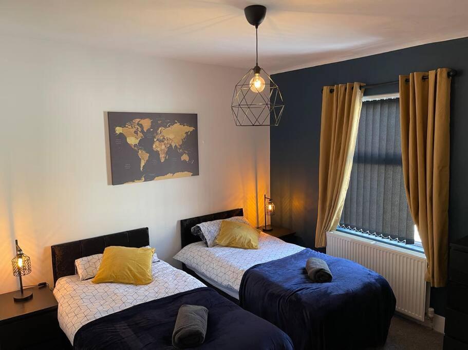 a bedroom with two beds and a map on the wall at Luxury accommodation. in Wallasey