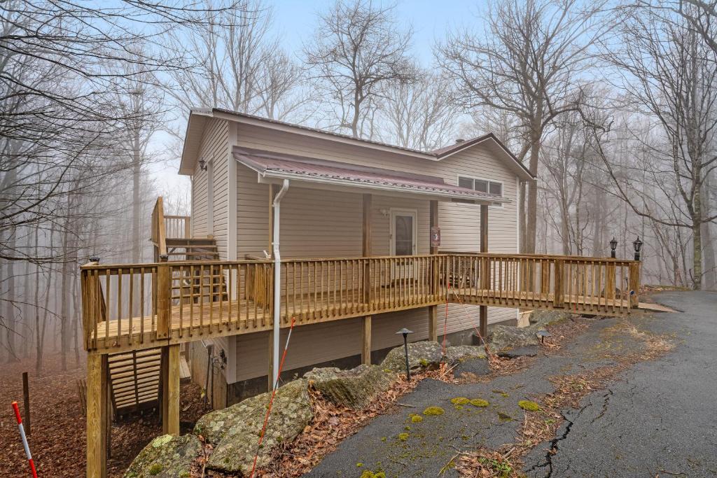 a small house with a wooden porch and a deck at Sandy Beech in Beech Mountain