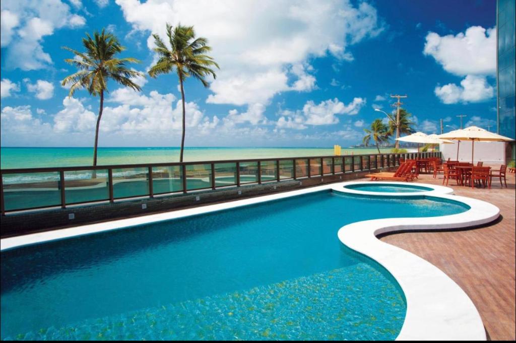 a swimming pool with a view of the beach at Flat novo à Beira-mar in Maceió