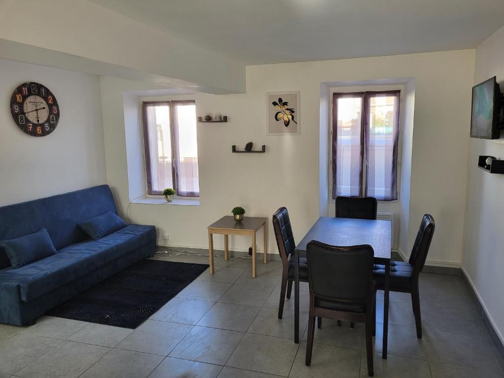 un soggiorno con divano blu e tavolo di Appartement en duplex a Évry-les-Châteaux