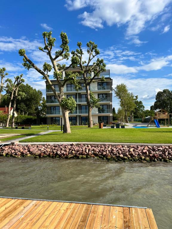 a building with a river in front of it at Platán Garden közvetlen vízparti apartman in Balatonboglár