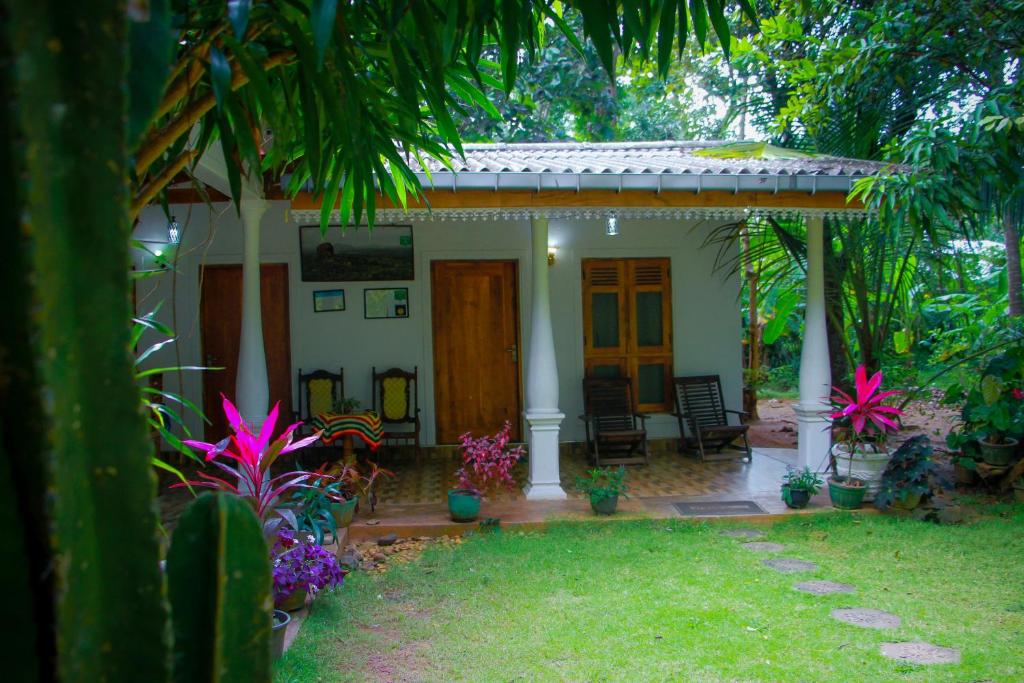 une petite maison avec une terrasse couverte et quelques plantes dans l'établissement Travelodge Sigiriya, à Sigirîya