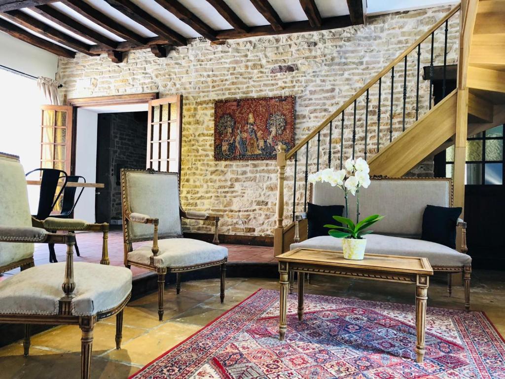 a living room with chairs and a table and stairs at Maison Céleste in Nuits-Saint-Georges