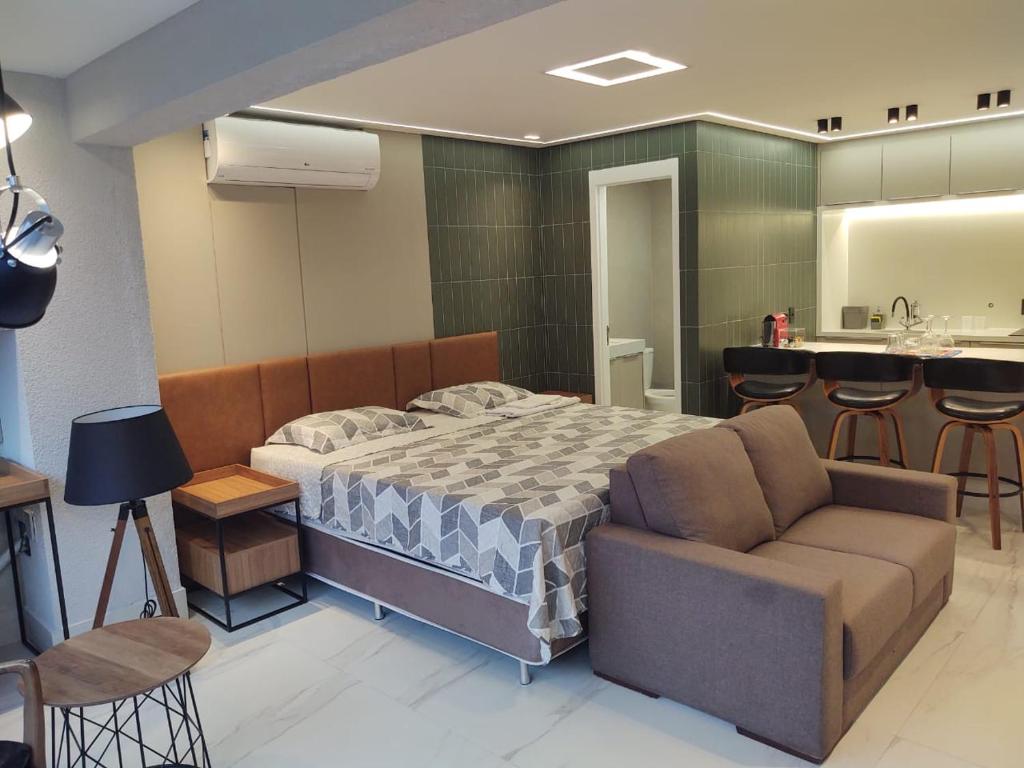 1 dormitorio con cama, sofá y cocina en apartamento 5 estrelas bela vista, en São Paulo