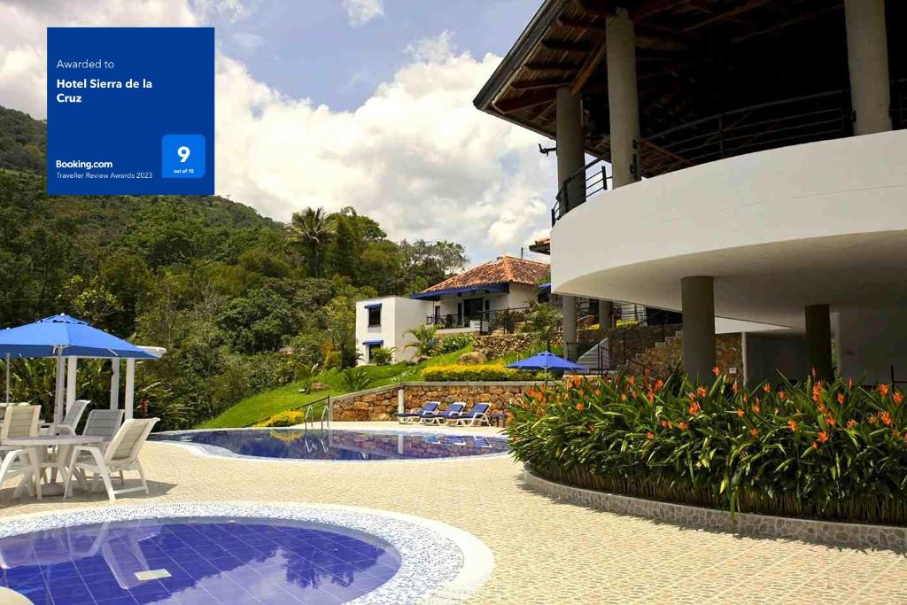 een resort met een zwembad en stoelen en een bord bij Hotel Sierra de la Cruz in Valle de San José