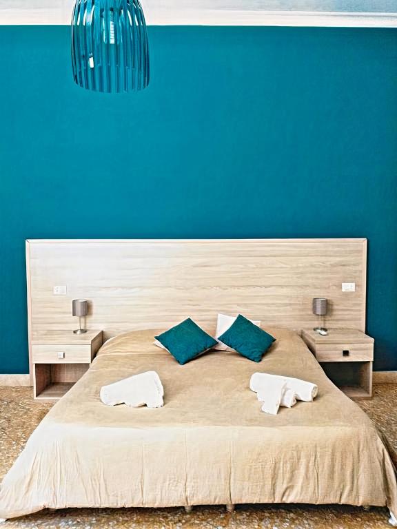a bedroom with a large bed with a blue wall at Il Quadrifoglio Room& Suite in Palermo