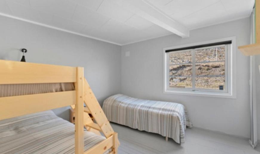 een slaapkamer met een stapelbed en een raam bij Lofoten Sunset & Ocean VIew in Valle