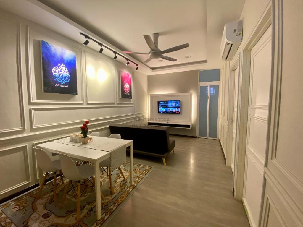 a living room with a table and a tv at Ali Homestay Sungai Petani in Sungai Petani