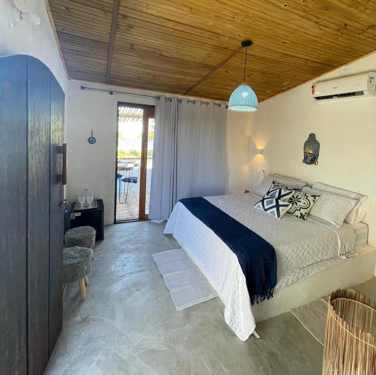 a bedroom with a large bed with a wooden ceiling at Aldeia Coqueiral in Caraíva