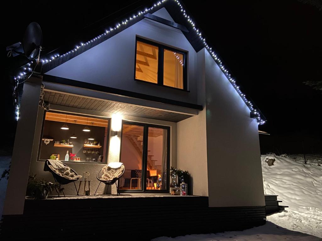 uma casa com luzes na neve em Cerla Korbielów - Domek dla Dwojga em Korbielów
