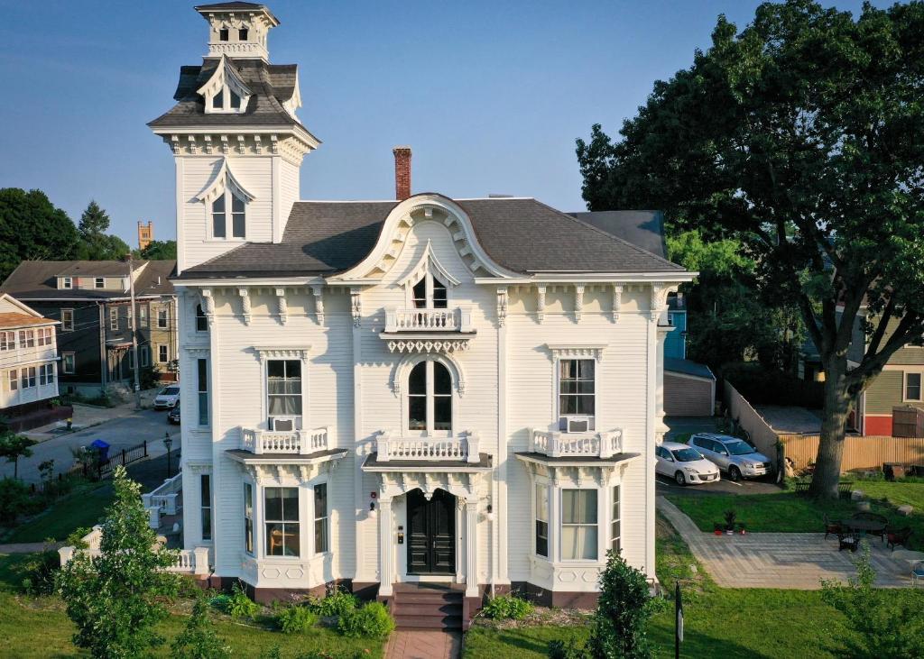 Une ancienne maison blanche avec une tour en haut dans l'établissement The Wedding Cake House, à Providence