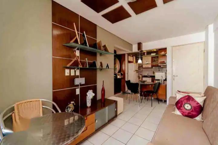 sala de estar con mesa y comedor en Apartamento aconchegante, en Natal