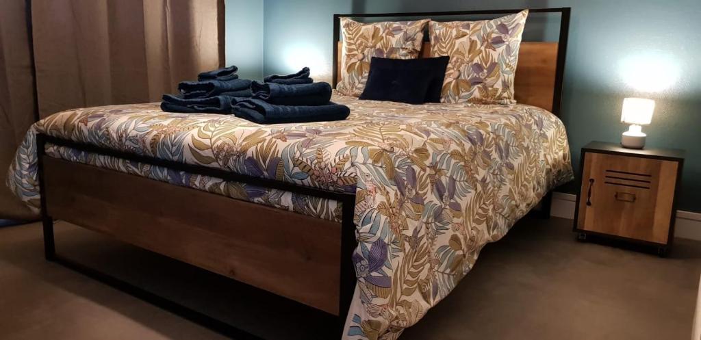 une chambre avec un lit et une table de chevet avec un lit sidx sidx dans l'établissement Au Cœur du Marché, à Boulogne-sur-Mer