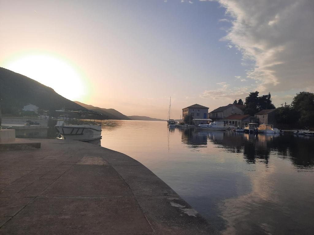 a view of a body of water with the sun setting at Cozy apartman in Luka