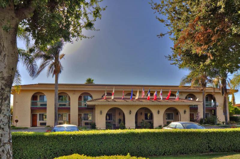 a large building with flags on top of it at Executive Inn Morgan Hill in Morgan Hill