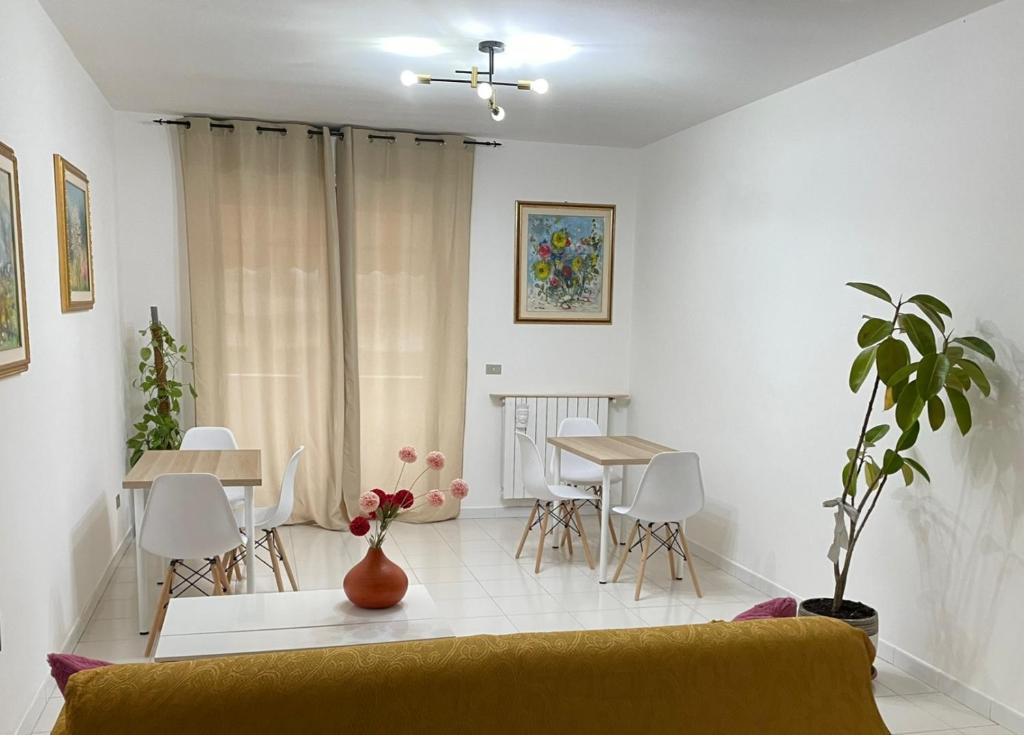 ein Wohnzimmer mit einem Sofa, einem Tisch und Stühlen in der Unterkunft B&b Binario38 in Benevento