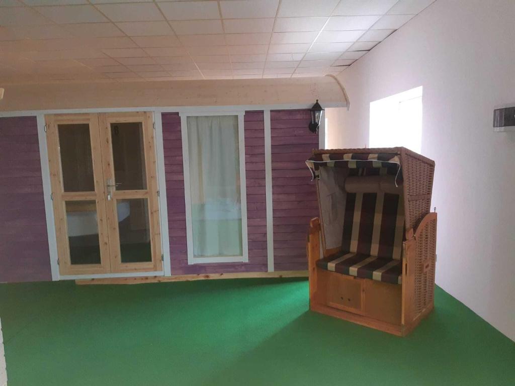 a room with a green floor and a large window at Pension Stettiner Hof in Eggesin