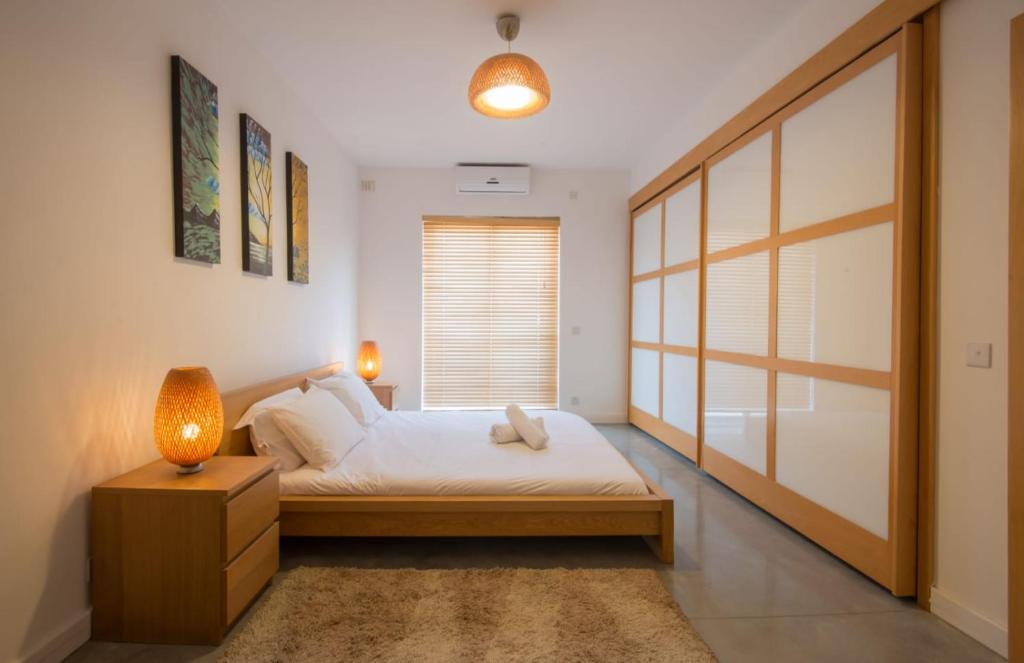 - une chambre avec un lit doté d'une lampe et d'une fenêtre dans l'établissement VBH PENTHOUSE SPINOLA ST. JULIAN'S, à San Ġiljan