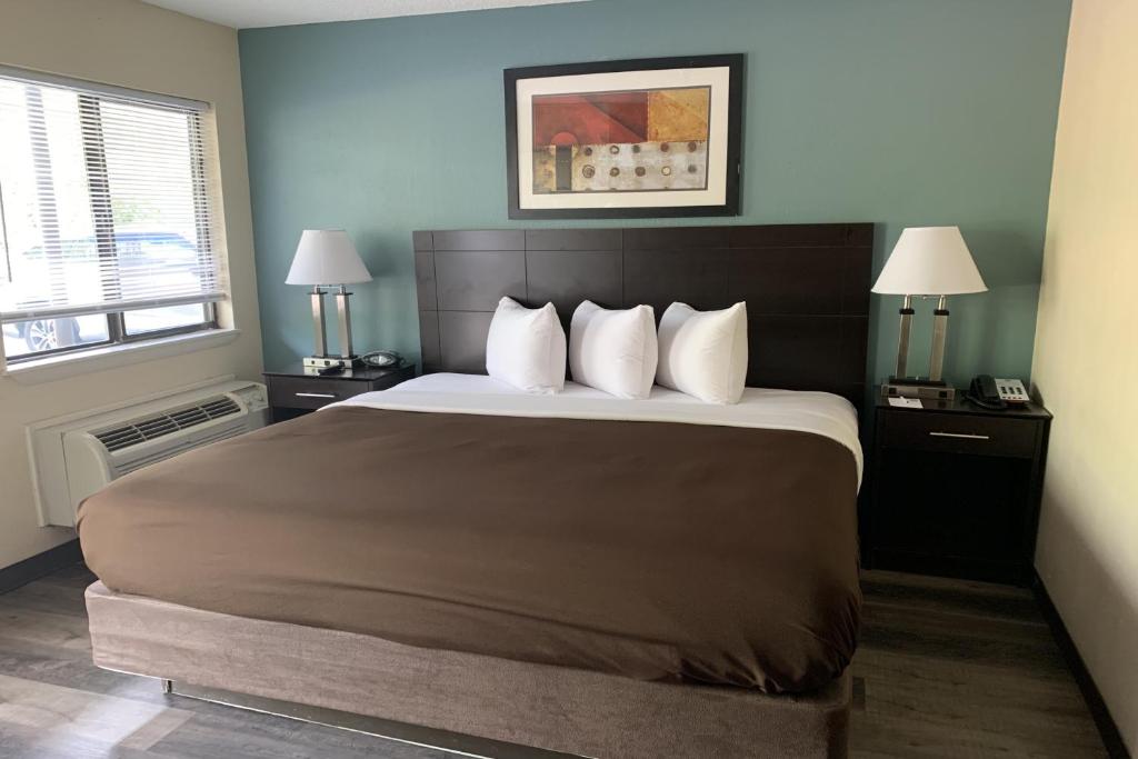 a bedroom with a large bed with white pillows at Suburban Studios in Augusta