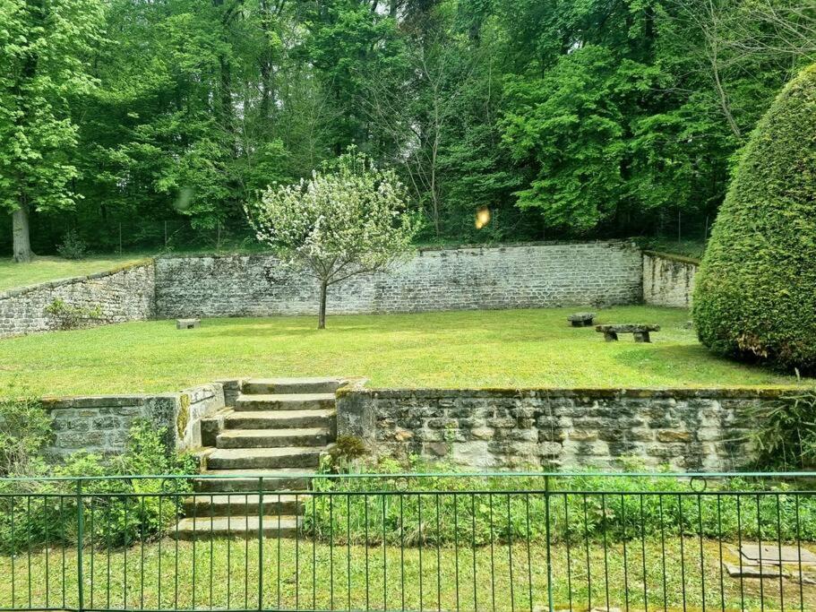 a park with a stone wall and stairs and a bench at L'Ourse, Epinal,très bel appartement quartier Port in Épinal