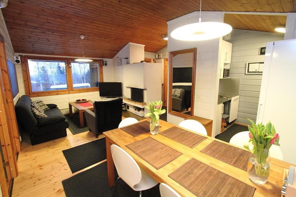 a living room with a wooden table and a dining room at Lomariihi 1 in Muurame