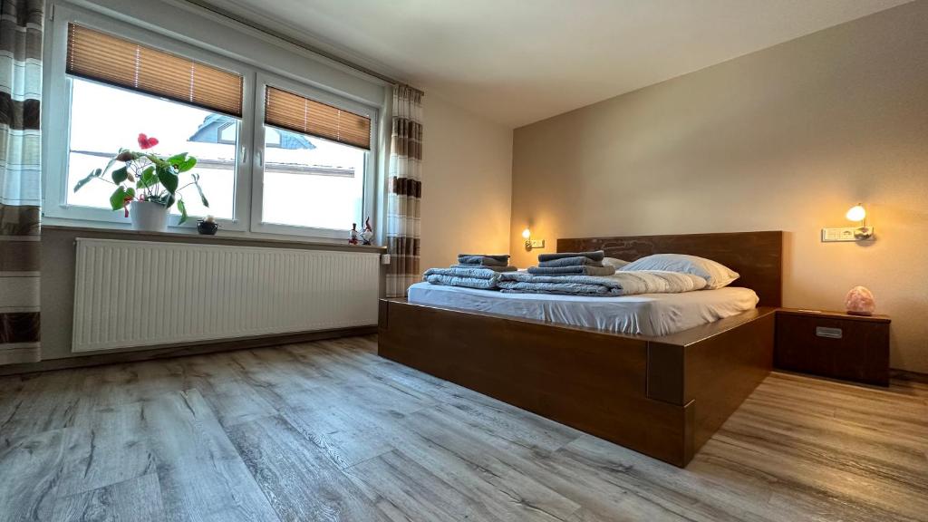 a bedroom with a large bed with a large window at Pension zum Winterberg in Elsterwerda
