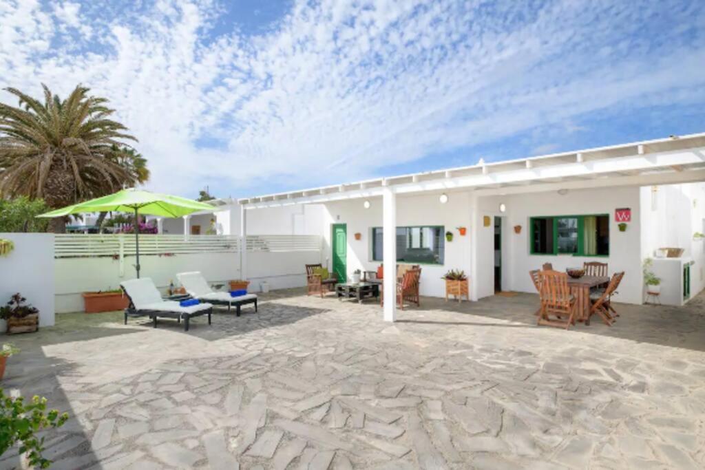 un patio con mesa y sillas y un edificio en Hermosa Casa vacacional, muy cerca a la playa., en Guatiza