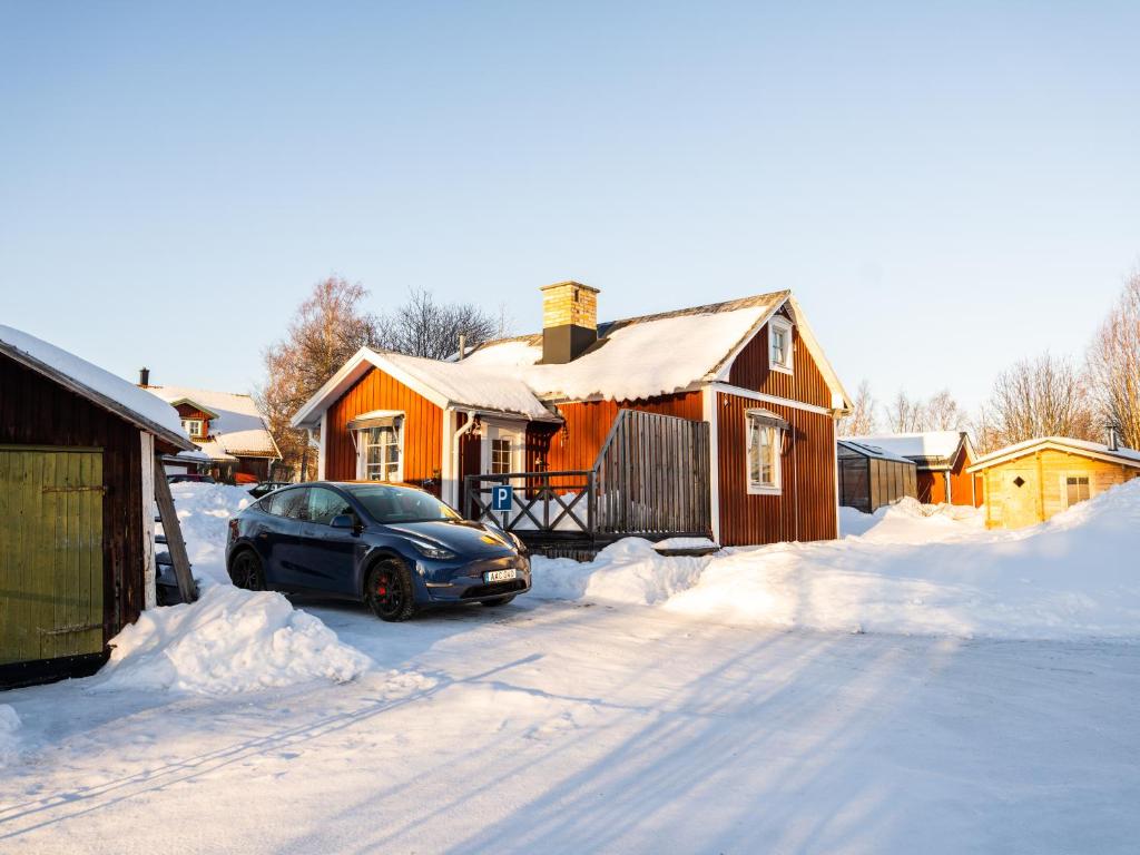 a car parked in the snow in front of a house at Luleå Village Cabin in Luleå